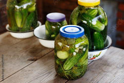 pickled cucumbers in glass jars on a wooden table