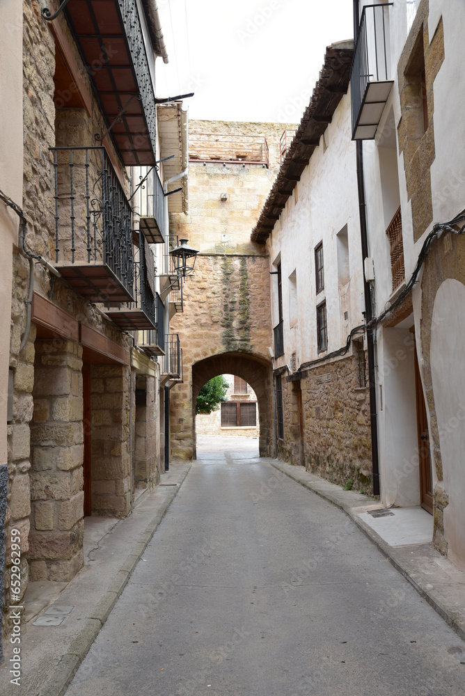 Street with an arch in the background made of stone from the medieval period, Spain