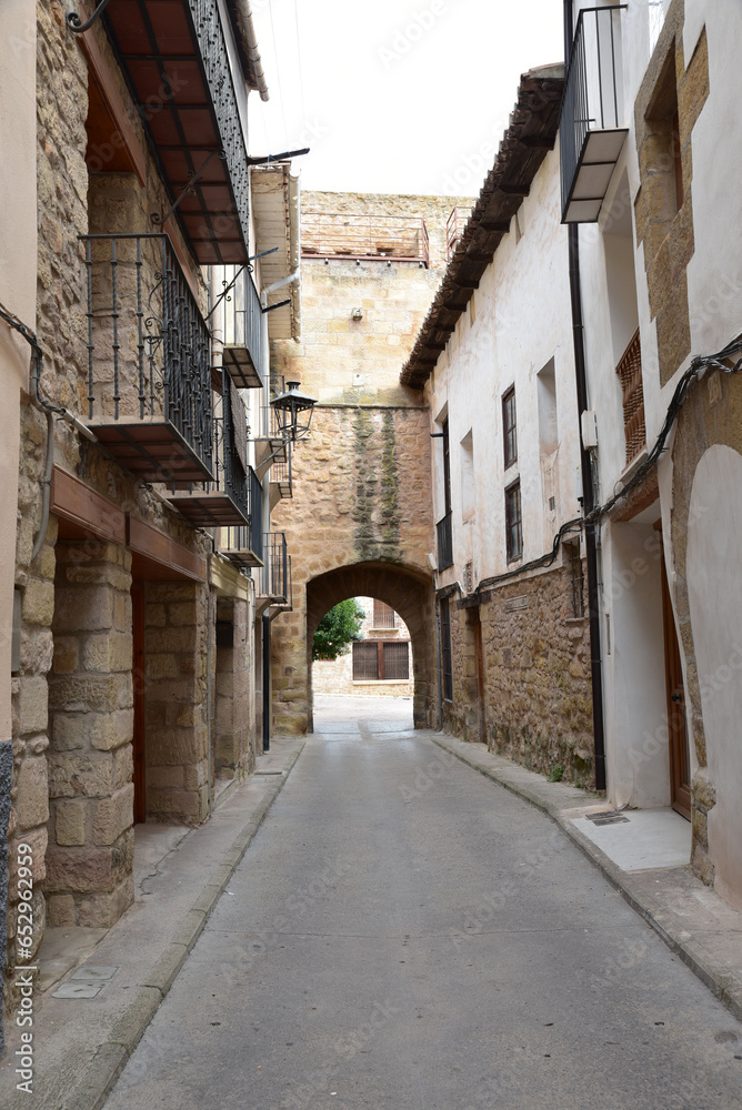 Obraz premium Street with an arch in the background made of stone from the medieval period, Spain