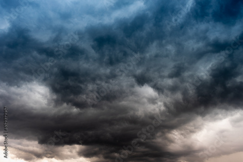 The dark sky with heavy clouds converging and a violent storm