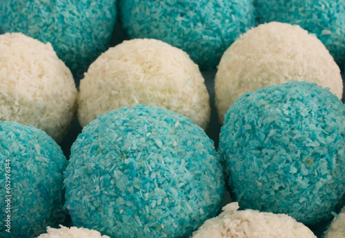 Fotografie Bonbons pralinés roulés dans des miettes de coco blanches et bleus