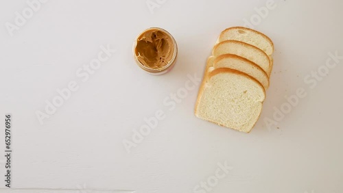 Close up of hands spreading peanut butter on a piece of bread