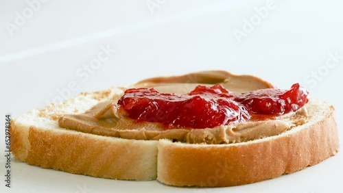 Close up of hands spreading jelly on a piece of bread