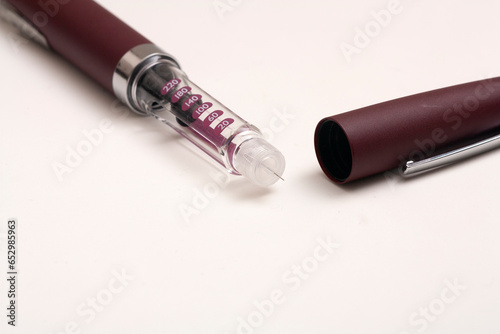 Insulin pen injector. Insulin pen fill with needle on white background. Diabetes Day.