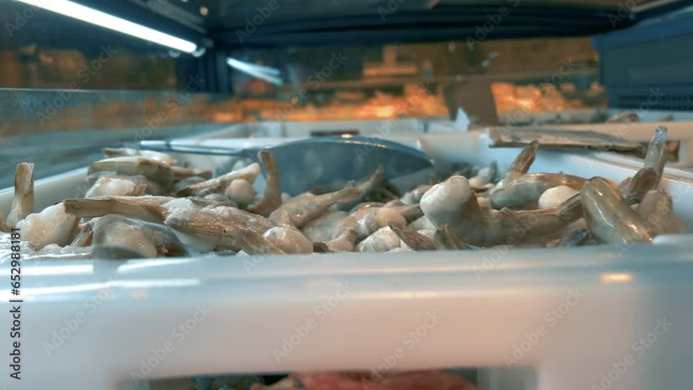 Frozen seafood shrimp, mussels, crustaceans on a refrigerator showcase