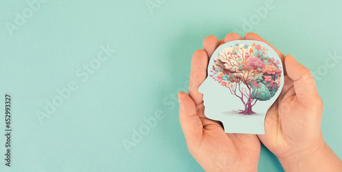 Hands holding head, human brain with flowers, self care and mental health concept, positive thinking, creative mind