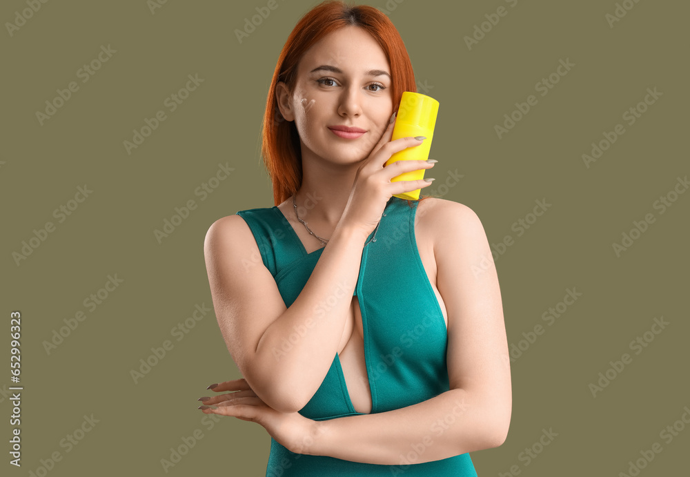 Young woman with heart made of sunscreen cream on green background Young woman with heart made of sunscreen cream on green background