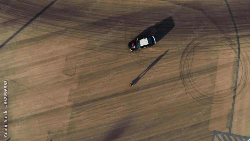 Epic high shot of cop car doing donuts around man