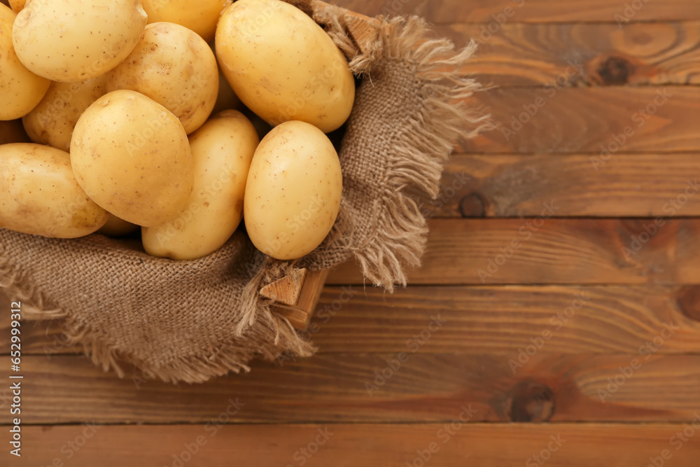 Box with raw potatoes on wooden background Box with raw potatoes on wooden background
