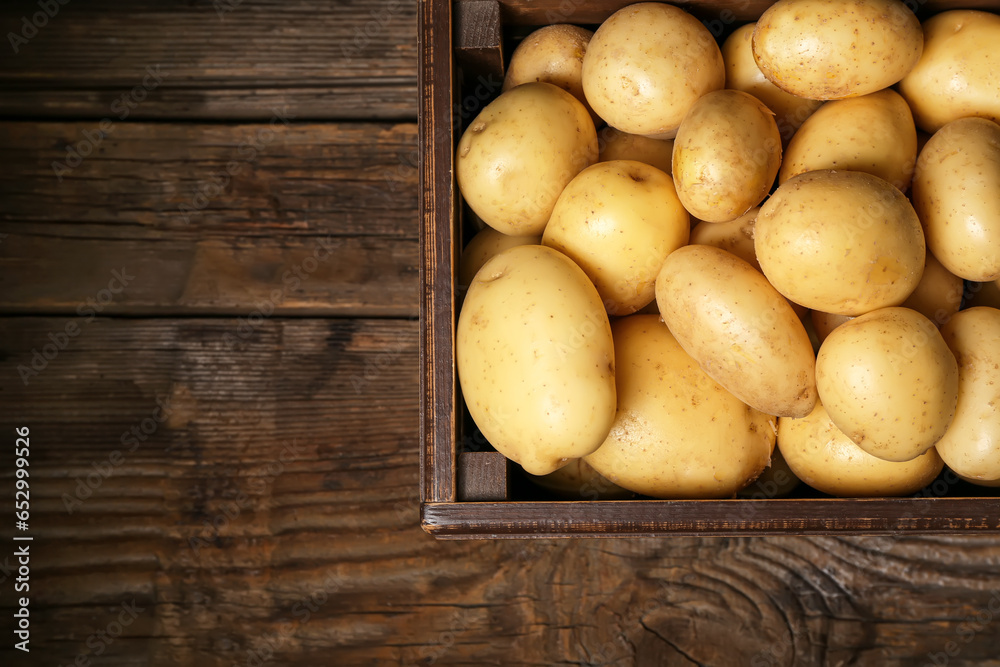Box with raw potatoes on wooden table Box with raw potatoes on wooden table