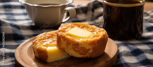 Close up photo of hot Minas Gerais cheese bread with black coffee butter and checkered picnic tablecloth