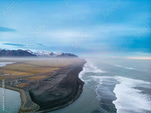 Famous magical black sand beach, atlantic ocean waves crashing on icelandic shoreline creating beautiful landscape. Drone shot of fantastic nordic scenery, strong tides with arctic weather.