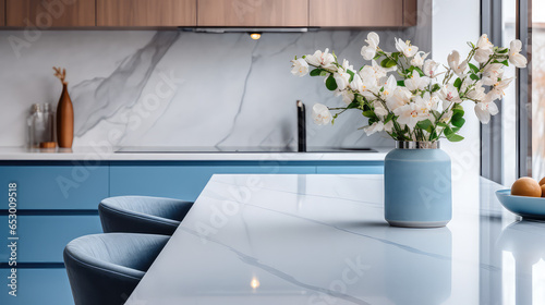 Vase with fresh spring flowers on dinning table on the background of modern kitchen in Scandinavian interior style. Light white blue colors. 