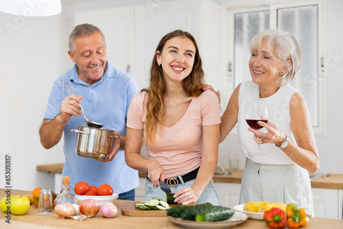 Happy family of three preparing lunch together in a modern kitchen