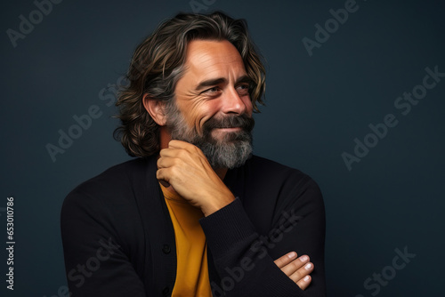 middle age man wearing casual clothes looking to the side in front a blue background. copy space.