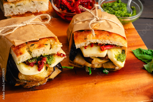 Italian Toasted Veggie Sandwiches Wrapped in Brown Paper: Rustic sandwiches with Mediterranean ingredients on toasted focaccia bread