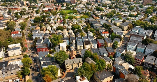 Flight above the rooftops of sunny Cambridge, Massachusetts, USA. Beautiful few-storied houses in the residential area of the city. photo