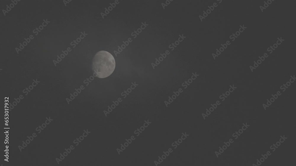 Tokyo, Japan - September 26, 2023: A half-moon gradually covered with faint clouds
