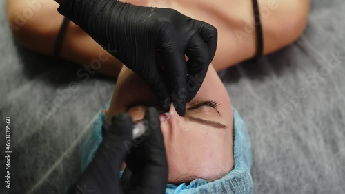 Woman getting beauty injection in cosmetic clinic. Close up cosmetologist doing botox injection in forehead to patient in beauty clinic. Rejuvenation, injectable cosmetology concept photo