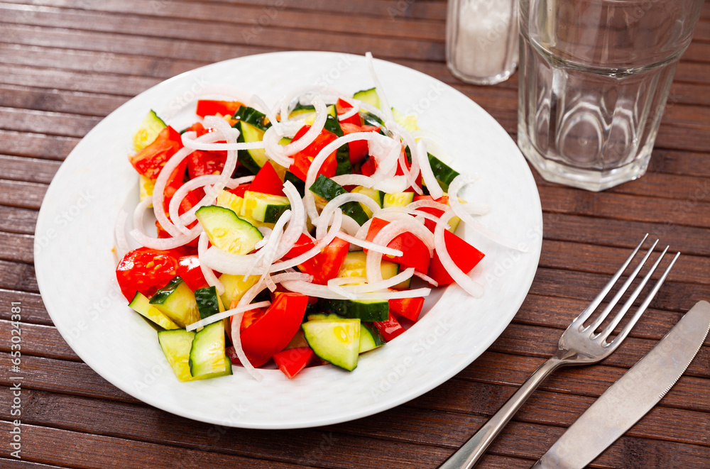 Healthy vegetable salad of sliced fresh tomatoes, cucumber and onion with olive oil