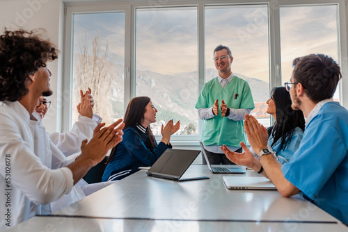 A medical team of doctors support and applause in celebration at the meeting in the office concept of teamwork leadership.