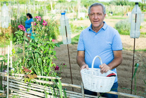 Portrait of elderly positive man on his farm on a summer day photo