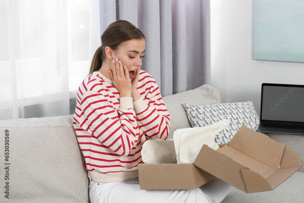 Emotional woman unpacking parcel at home. Online store Emotional woman unpacking parcel at home. Online store