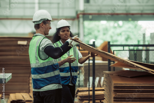 The tech prepare cardboard sheet with precision before automating production in the paper factory.