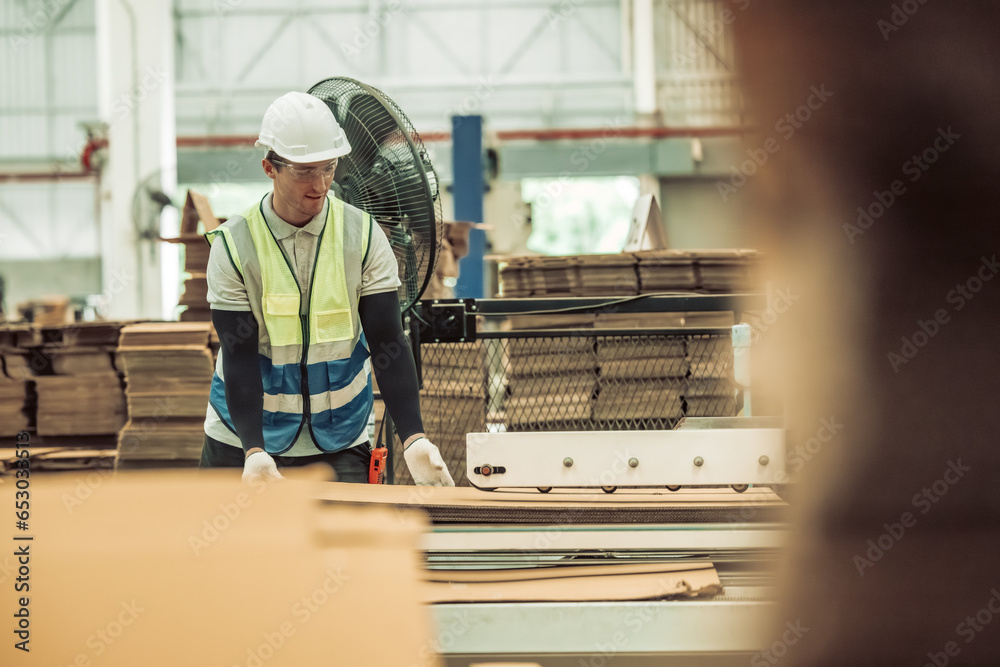 The tech prepare cardboard sheet with precision before automating production in the paper factory. The tech prepare cardboard sheet with precision before automating production in the paper factory.