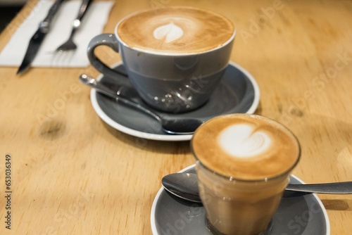 Photography A grey coffee cup and saucer of flat white coffee, and a smaller piccolo in a gl