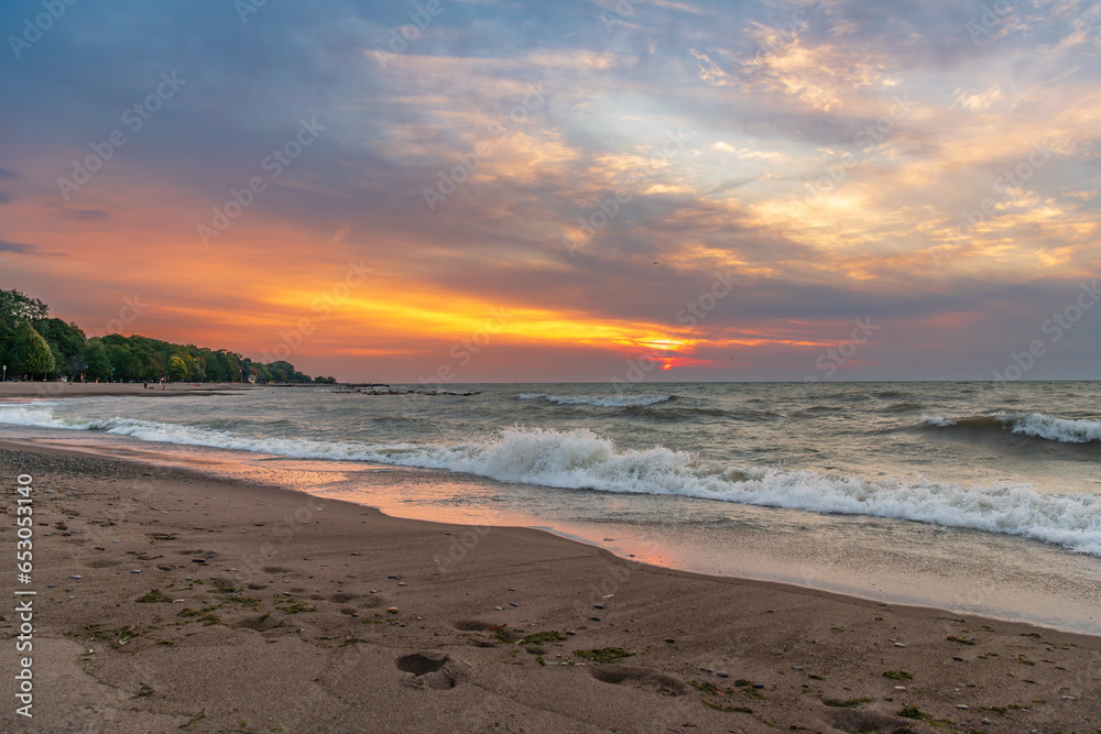 kew beach in toronto's beaches neighbourhood sunrise with clouds and waves room for text