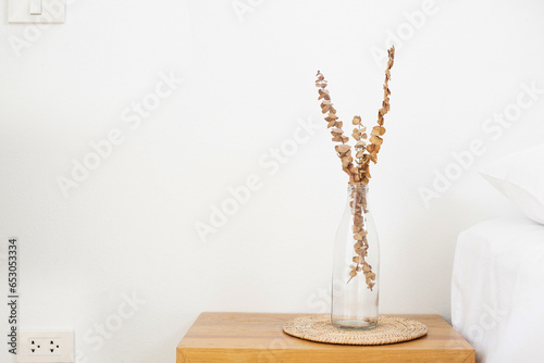 Brown dried flowers in a white vase