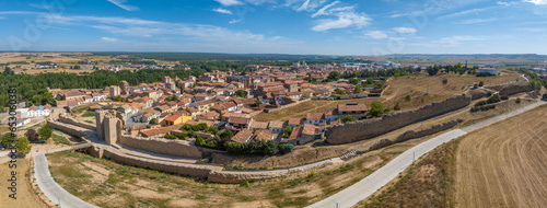 Aerial view of Almazan city walls, fortified gate, battlements above the Ebro river in Spain with cloudy blue sky