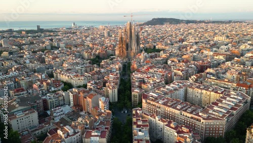 Establishing aerial view shot Barcelona Eixample residential district and famous Basilica Sagrada Familia at sunrise. Catalonia, Spain photo