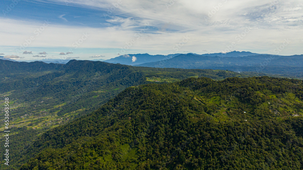 Mountain slopes with rainforest and a mountain valley with farmland. Sumatra. Indonesia.