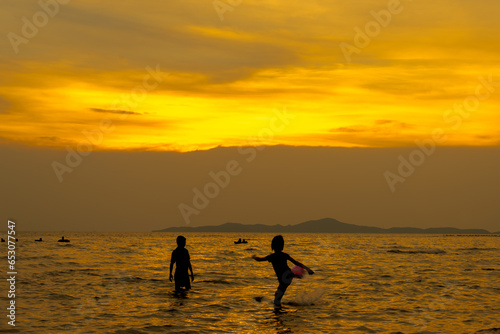 
The sea in the evening and children having fun playing in the water. The sun sets.