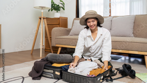 Young woman sit in floor and preparation suitcase for weekend trip. travel concept