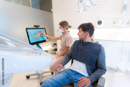 Dentist using modern technology to explain procedure to a man photo