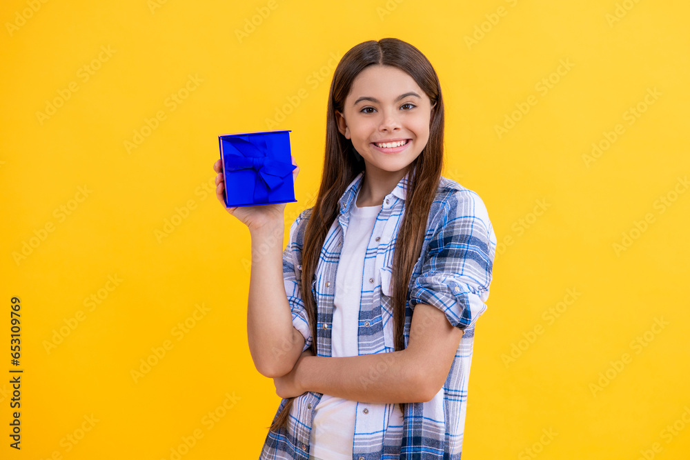 Portrait of happy teen girl with birthday gift isolated on yellow. teen girl celebrate birthday with present in studio. teen girl holding birthday present box on background. birthday teen girl posing Portrait of happy teen girl with birthday gift isolated on yellow. teen girl celebrate birthday with present in studio. teen girl holding birthday present box on background. birthday teen girl posing