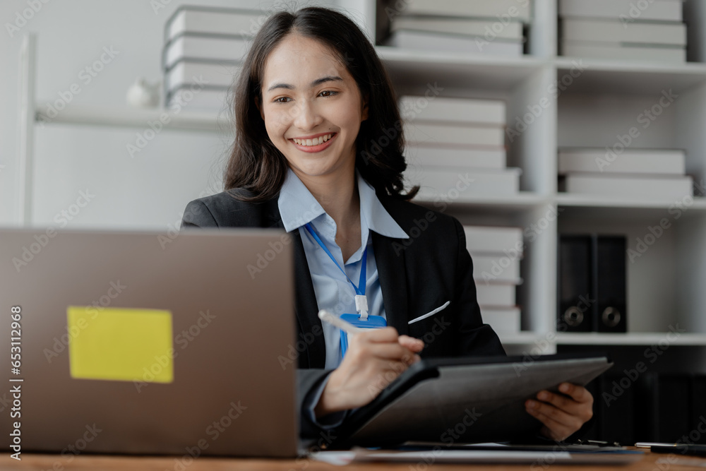 Woman sitting and working at a startup company, business woman finances financial auditing and financial planning for the company. Concepts of financial management and financial statements. Woman sitting and working at a startup company, business woman finances financial auditing and financial planning for the company. Concepts of financial management and financial statements.