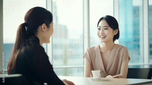 Two Japanese women talking in a bright office