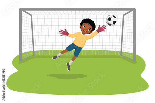 Cute little African boy goalkeeper catching a soccer ball to prevent a goal