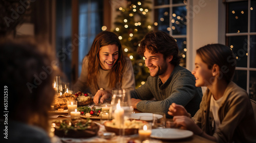 Family having Christmas dinner at home gathered together. holidays  celebration and people concept - happy smiling friends having christmas dinner at home in evening