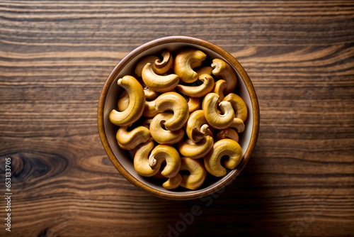 Cashew nuts on bowl top view on wooden table with copy space for text food photography