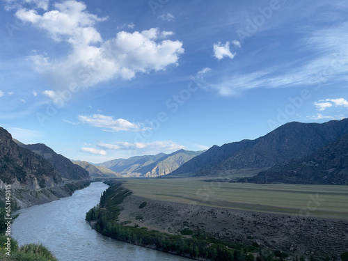 Mountain landscape with river and blue sky. 