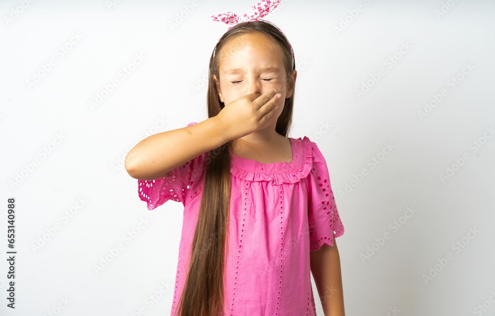 beautiful kid girl wearing pink dress smelling something stinky and