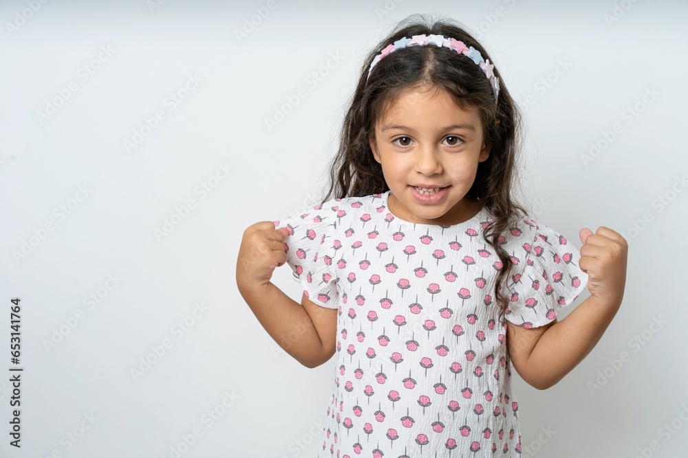 beautiful kid girl wearing dress celebrating surprised and amazed for success with arms raised and eyes closed. Winner concept. beautiful kid girl wearing dress celebrating surprised and amazed for success with arms raised and eyes closed. Winner concept.
