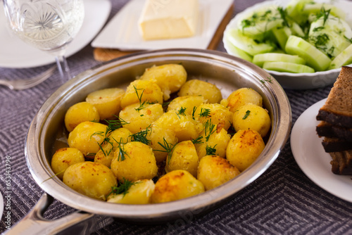 Roasted young potatoes with dill in metal skillet