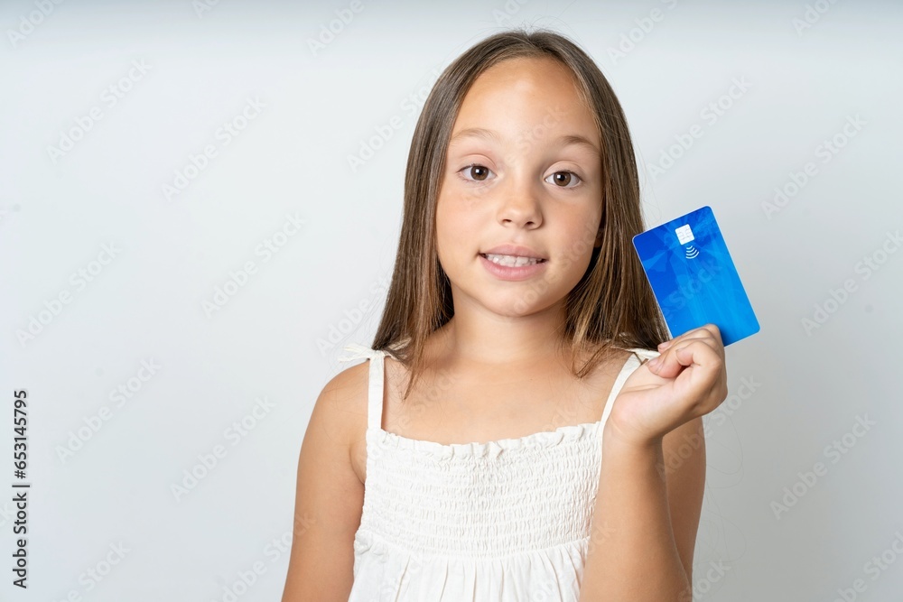 Photo of happy cheerful smiling positive beautiful kid girl wearing white dress recommend credit card Photo of happy cheerful smiling positive beautiful kid girl wearing white dress recommend credit card