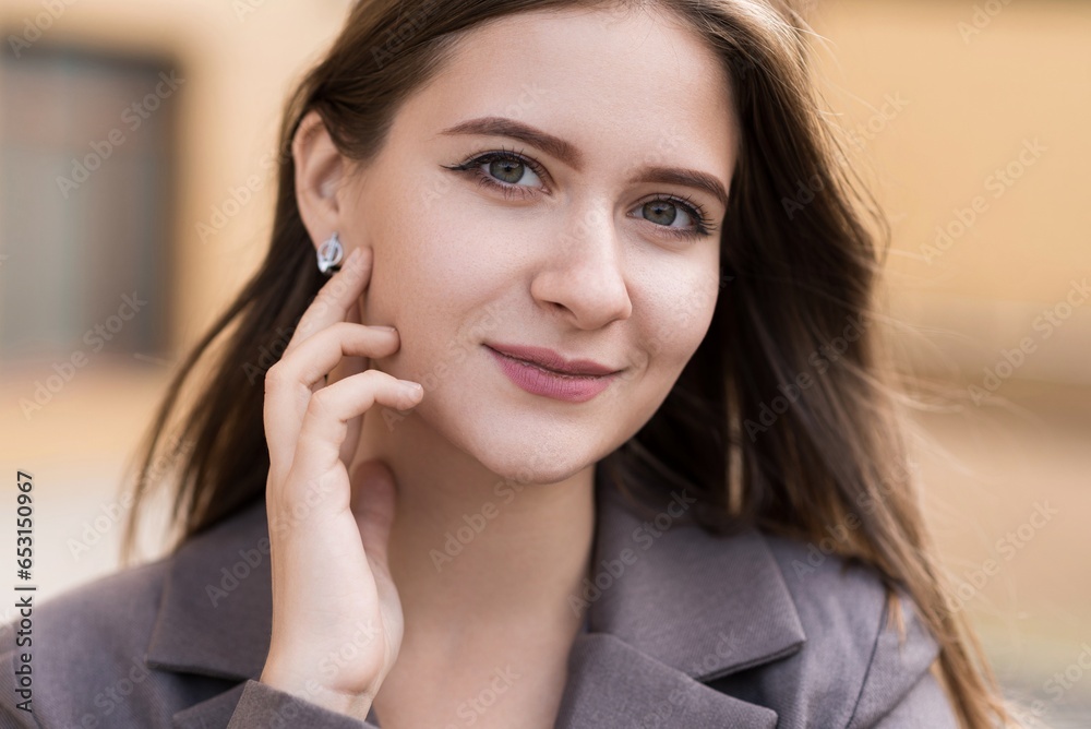 A close-up portrait of a Caucasian attractive and happy young woman in casual clothes in the city while walking on a sunny day. The concept of style, fashion, youth and lifestyle A close-up portrait of a Caucasian attractive and happy young woman in casual clothes in the city while walking on a sunny day. The concept of style, fashion, youth and lifestyle